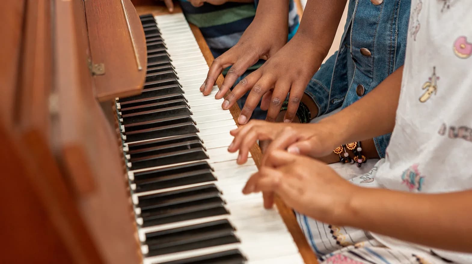 Kinderen spelen samen op de piano bij de BSO van kinderopvang Kind&co ludens