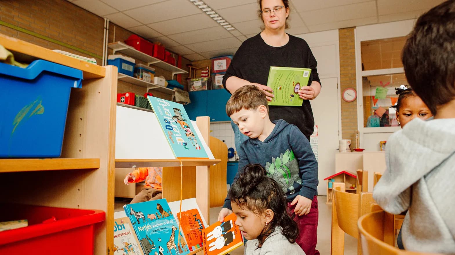 Kinderen met leesboekjes in de groepsruimte bij Peuteropvang De Cirkel Utrecht van kinderopvang Kind&co ludens