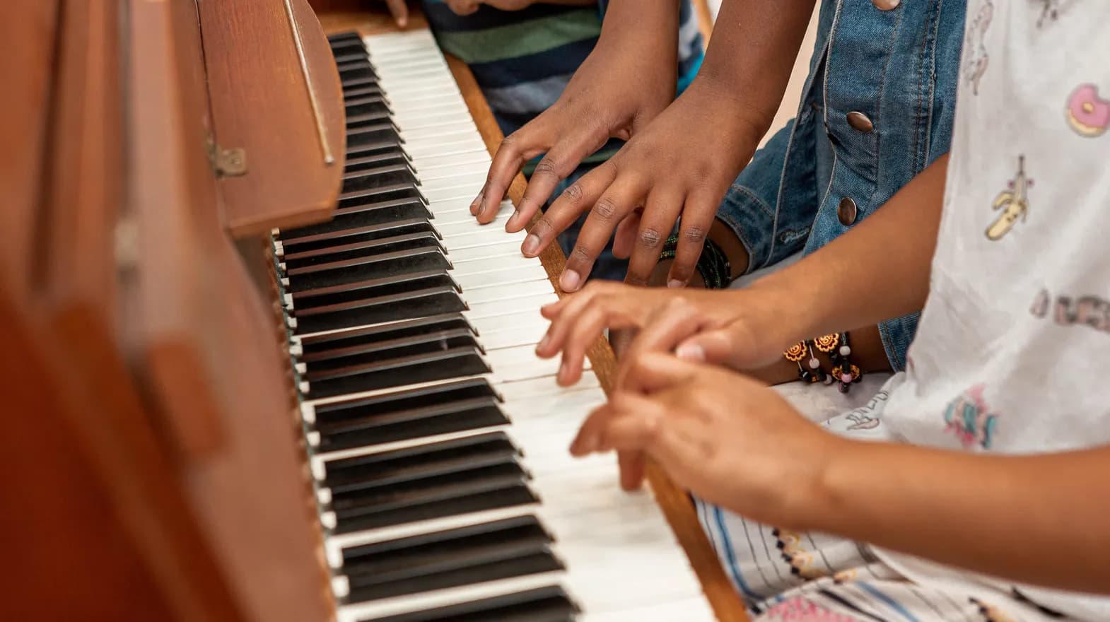 Kinderen spelen samen op de piano bij de BSO van kinderopvang Kind&co ludens