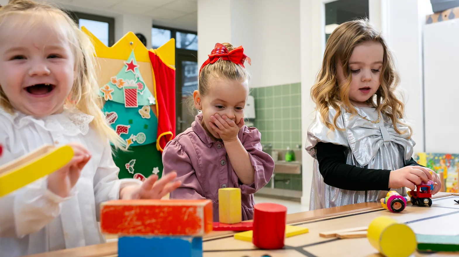Kinderen van de peutergroep lachen en spelen samen bij kinderopvang Kind&co ludens