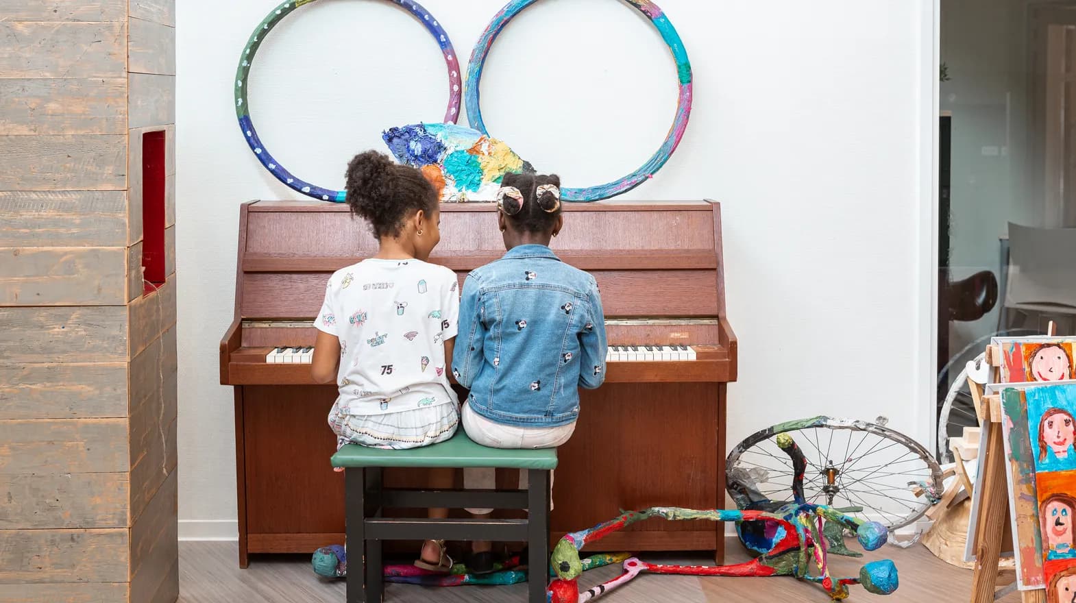 Kinderen spelen samen op de piano bij de BSO van kinderopvang Kind&co ludens