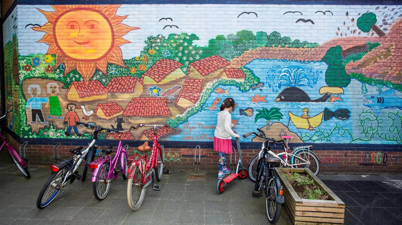 Een beschilderde muur op het speelplein van buitenschoolse opvang Maanvis, kinderopvang Kind&co Ludens