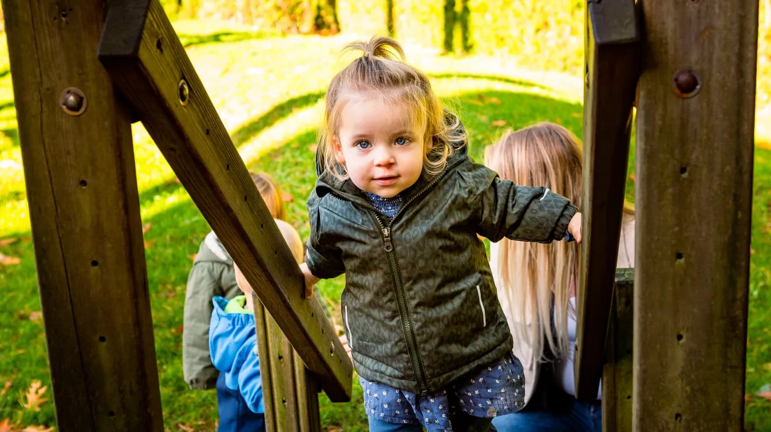 Kind speelt buiten op een speeltoestel bij kinderopvang Kind&co ludens