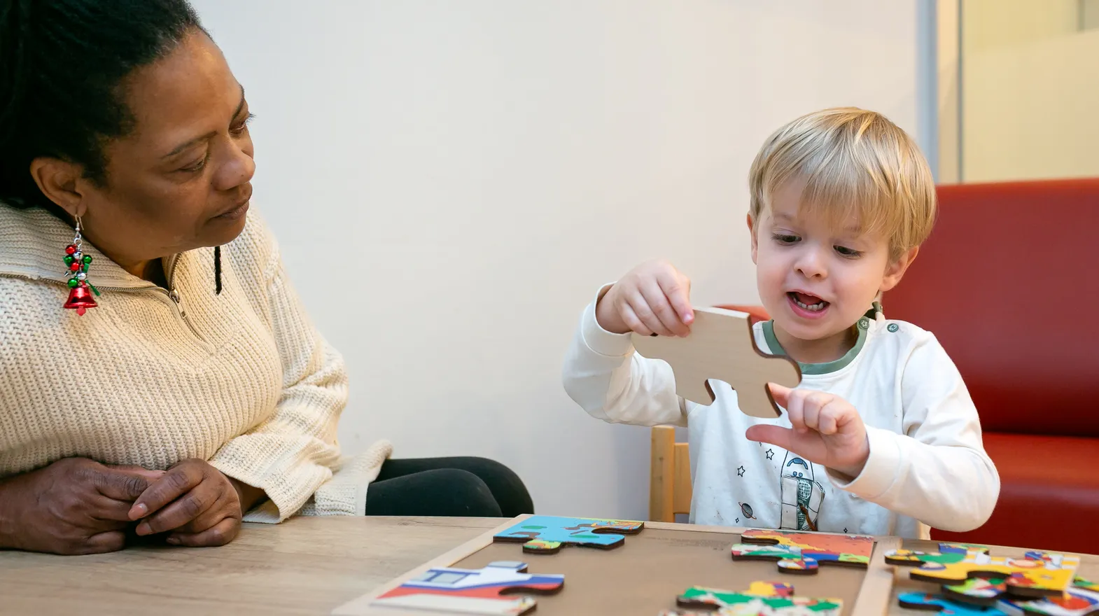 Kind puzzelt samen met pedagogisch medewerker van kinderdagverblijf Avontuur bij kinderopvang Kind&co Ludens