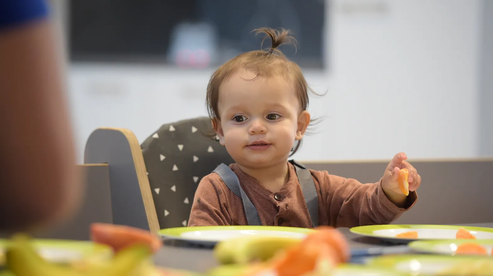 Baby is lekker aan het eten tijdens de lunch bij kinderopvang Kind&co ludens