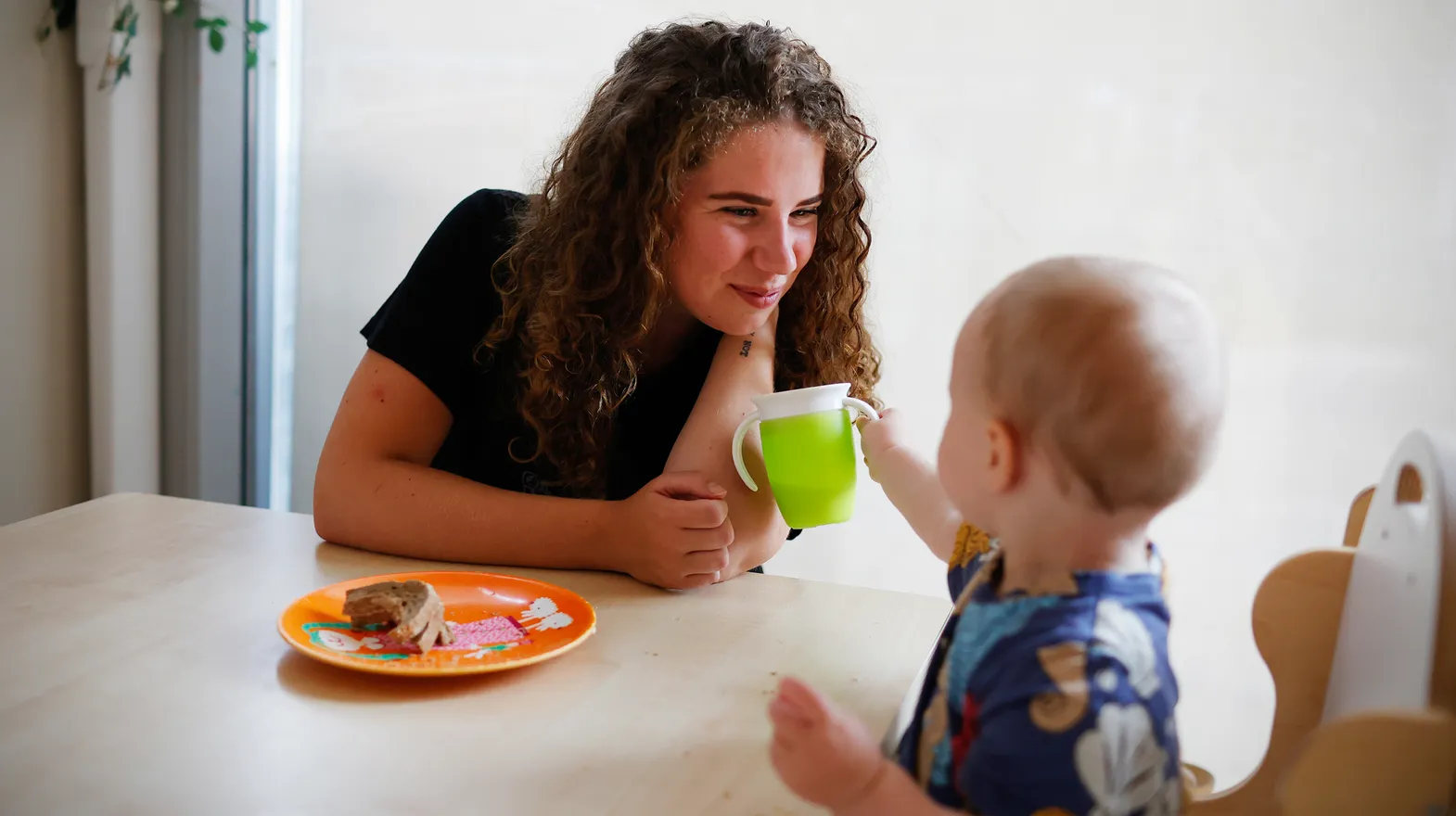 Kind eet samen met pedagogisch medewerker bij kinderopvang Kind&co ludens