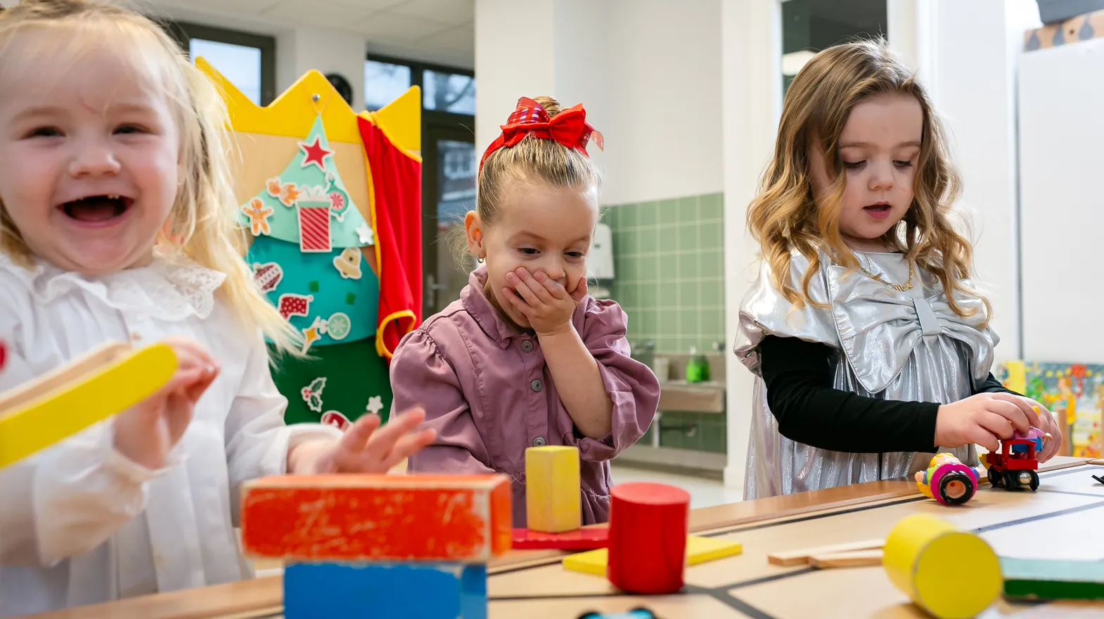 Kinderen van de peutergroep lachen en spelen samen bij kinderopvang Kind&co ludens