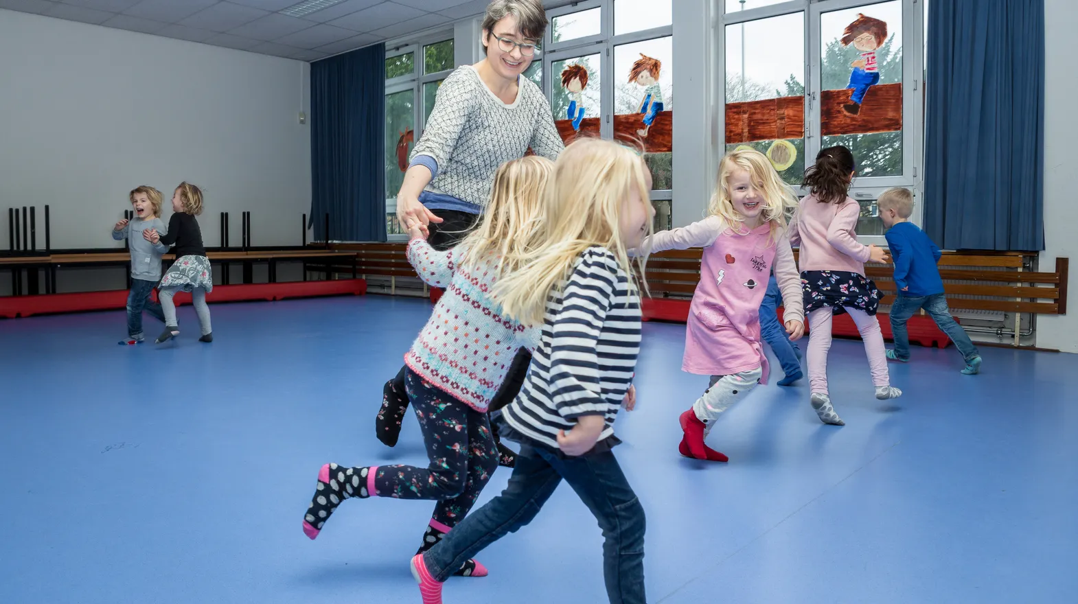 Kinderen van de BSO sporten samen in de gymzaal bij kinderopvang Kind&co ludens