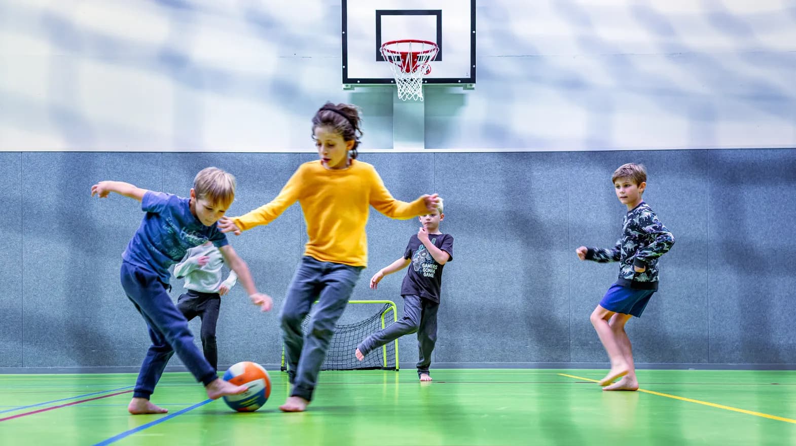 Kinderen van de BSO spelen samen voetbal in de gymzaal bij kinderopvang Kind&co ludens