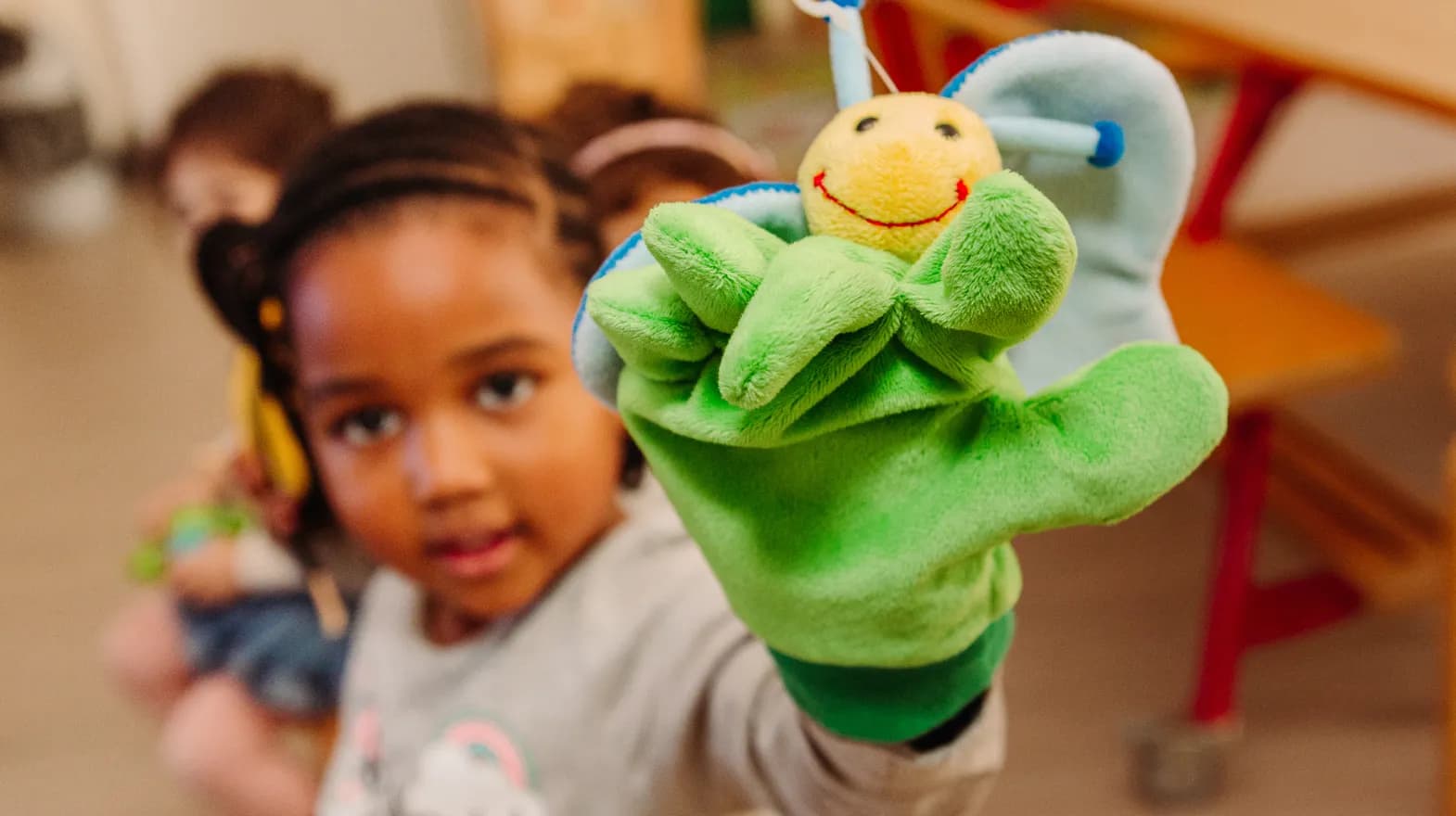 Kind van de peutergroep speelt met handpop bij kinderopvang Kind&co ludens