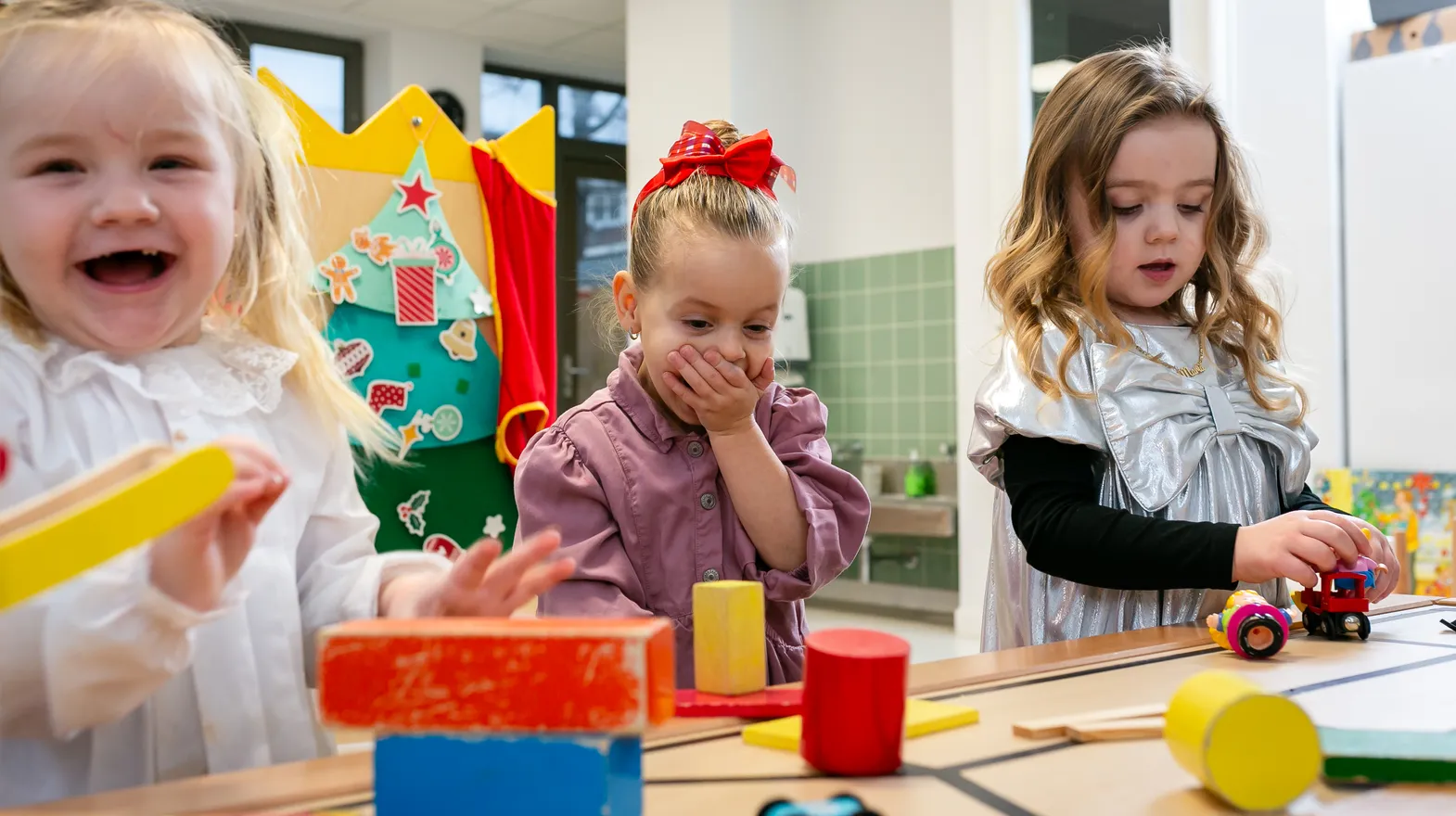 Kinderen van de peutergroep lachen en spelen samen bij kinderopvang Kind&co ludens
