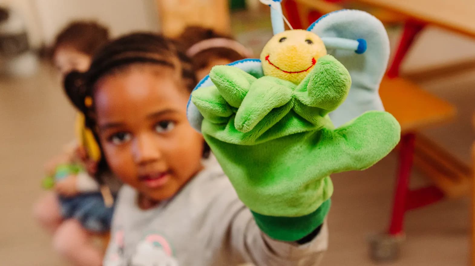 Kind van de peutergroep speelt met handpop bij kinderopvang Kind&co ludens