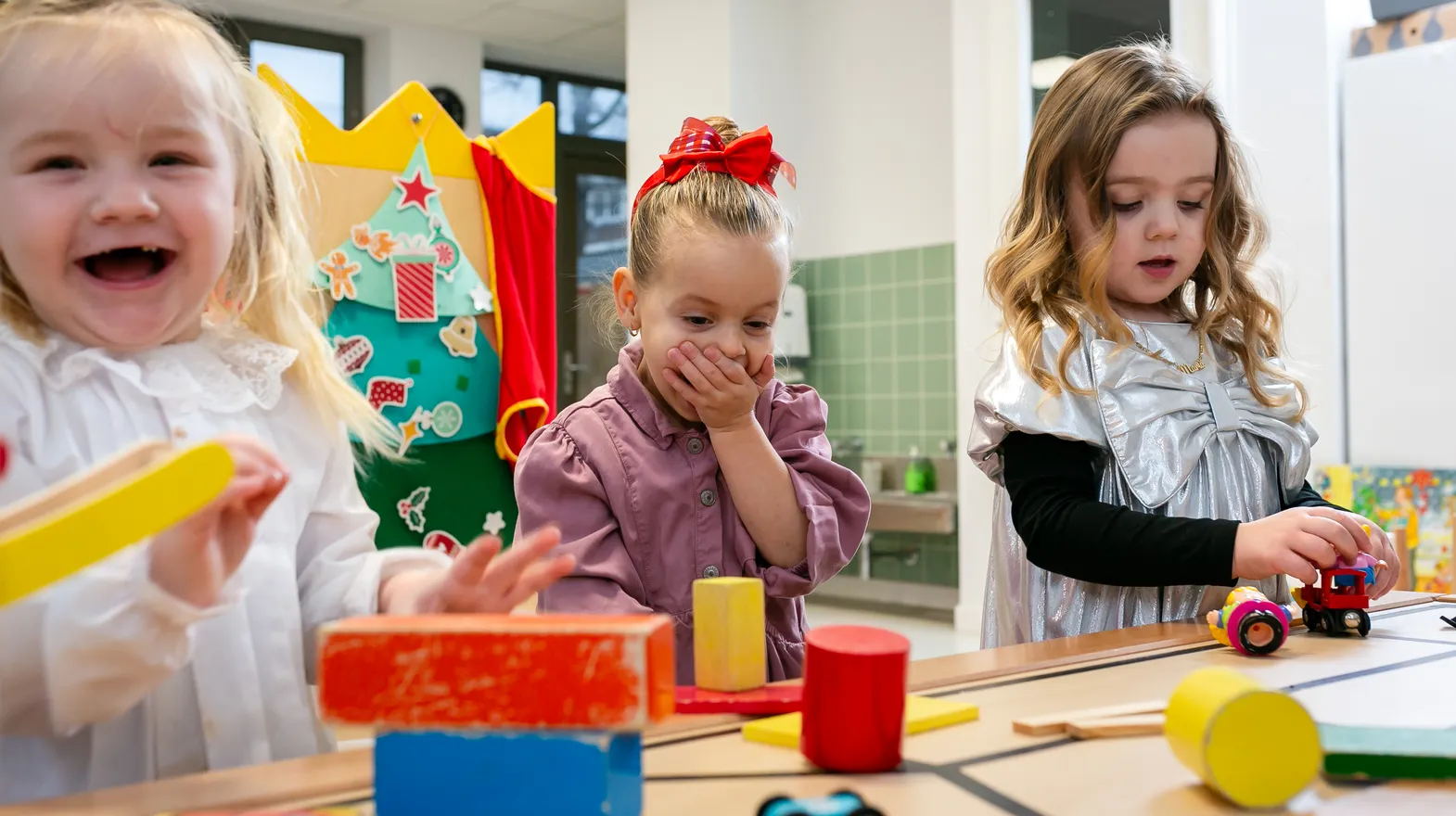 Kinderen van de peutergroep lachen en spelen samen bij kinderopvang Kind&co ludens
