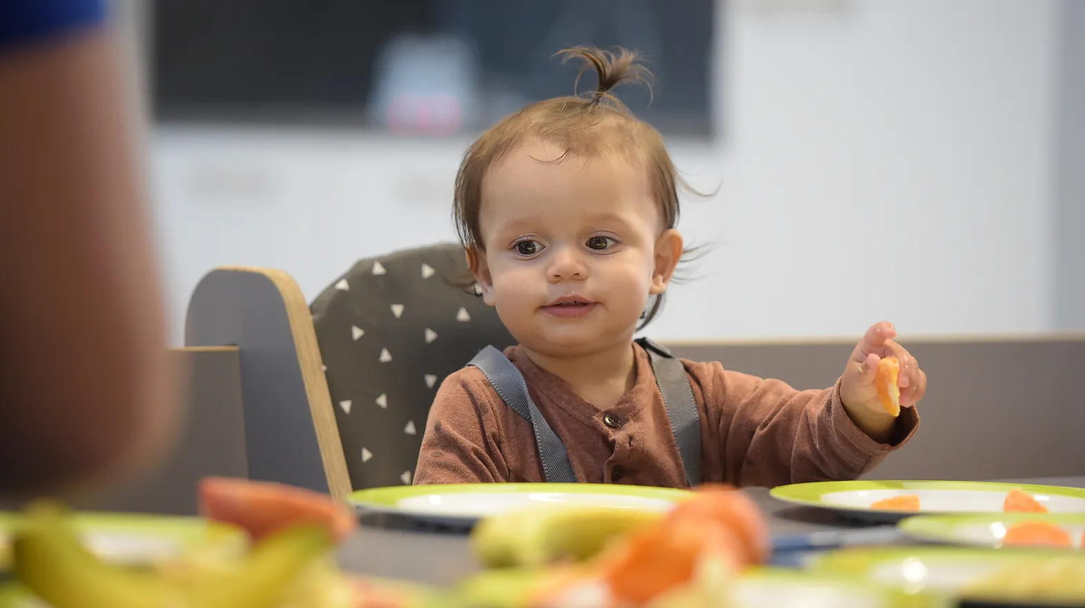 Baby is lekker aan het eten tijdens de lunch bij kinderopvang Kind&co ludens