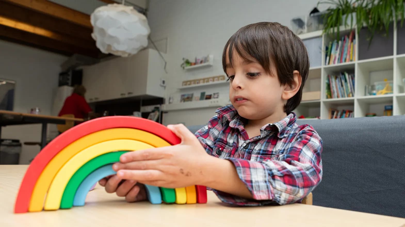 Kind speelt met houten regenboog bij buitenschoolse opvang Ay van kinderopvang Kind&co ludens