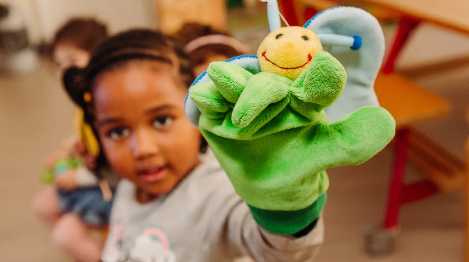 Kind van de peutergroep speelt met handpop bij kinderopvang Kind&co ludens