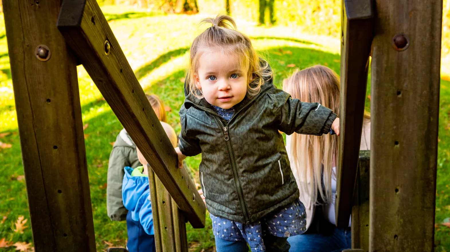Kind speelt buiten op een speeltoestel bij kinderopvang Kind&co ludens
