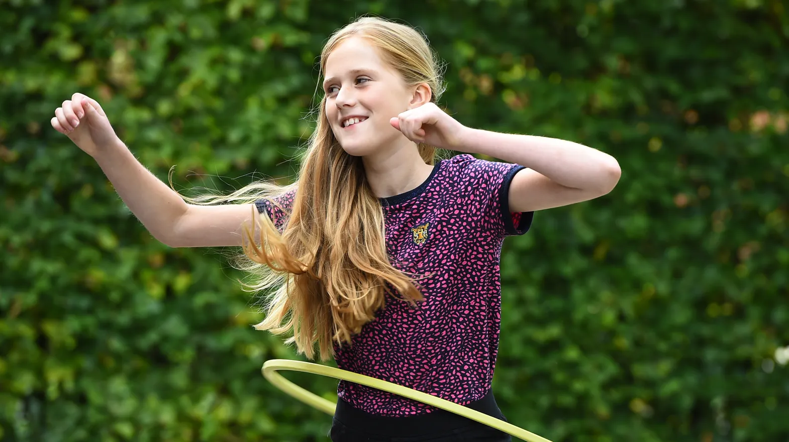 Kind van de BSO hoepelt buiten bij kinderopvang Kind&co ludens