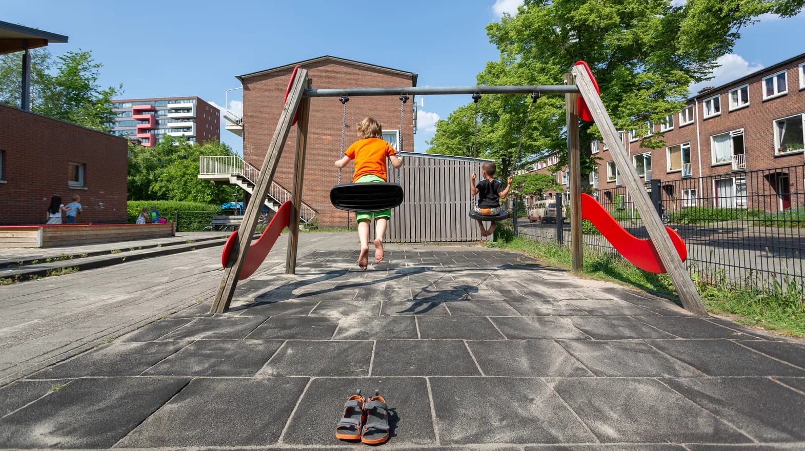 Kinderen spelen buiten op de schommel bij BSO Utrecht De Leeuw van kinderopvang Kind&co ludens