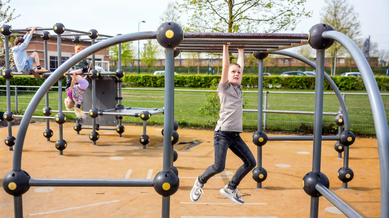 Kinderen spelen buiten in klimrek bij kinderopvang Kind&co ludens