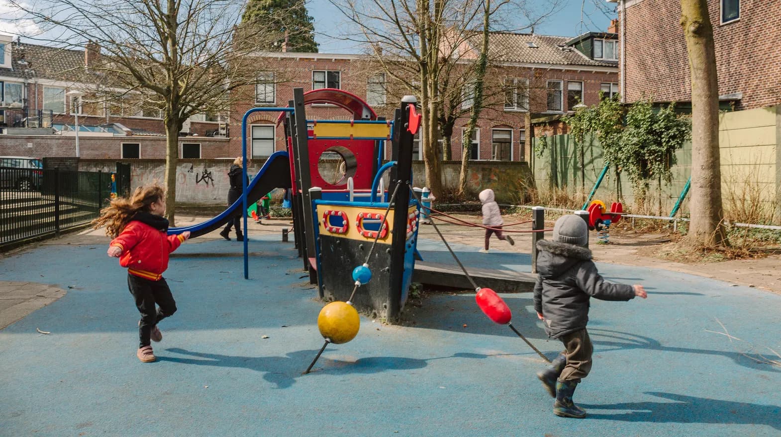 Kinderen spelen buiten met een speeltoestel bij kinderopvang Kind&co ludens