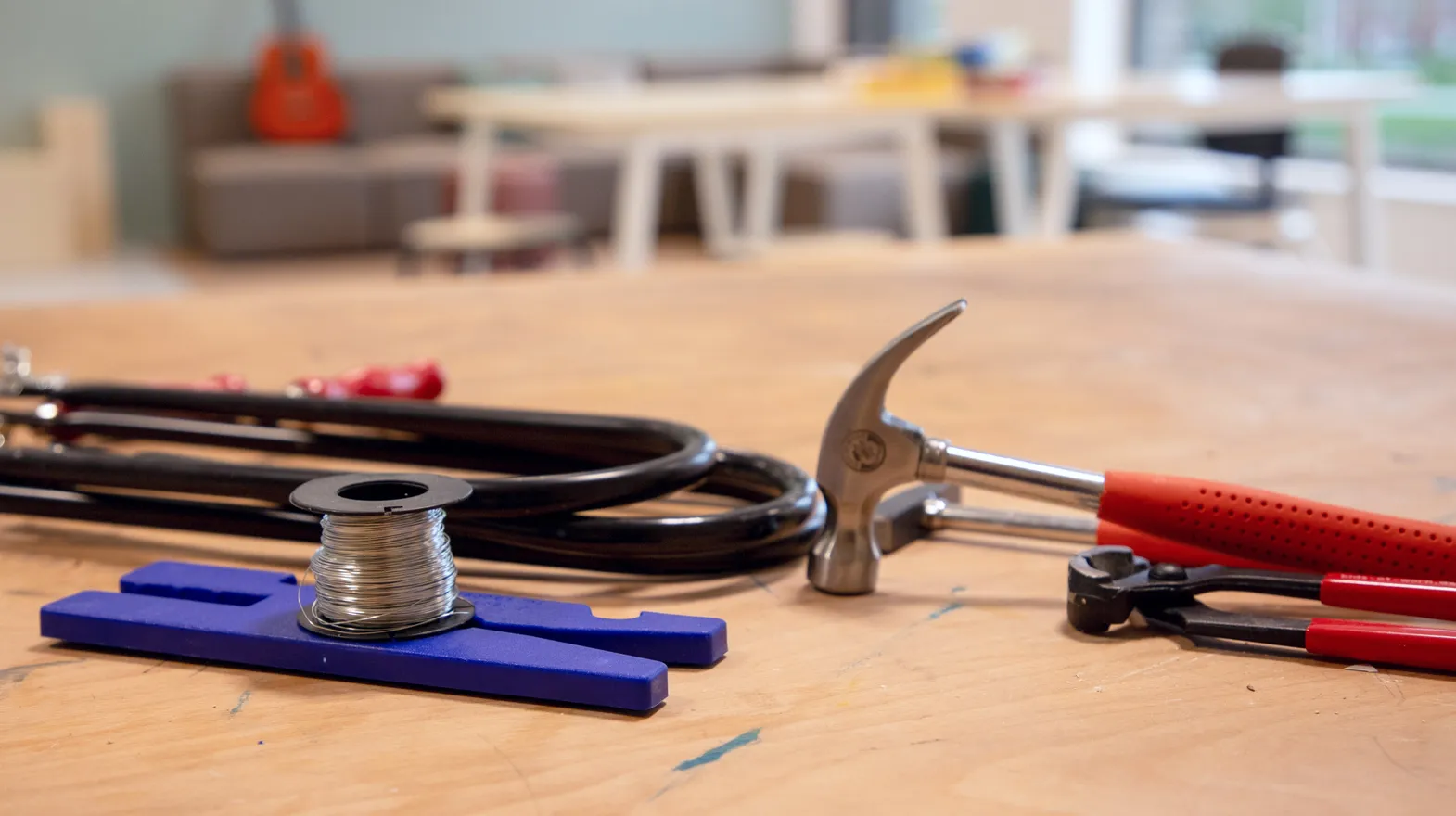 Hamer, ijzerdraad, tang en figuurzagen liggen op een tafel bij buitenschoolse opvang Leeuwesteyn, Kinderopvang Kind&co ludens
