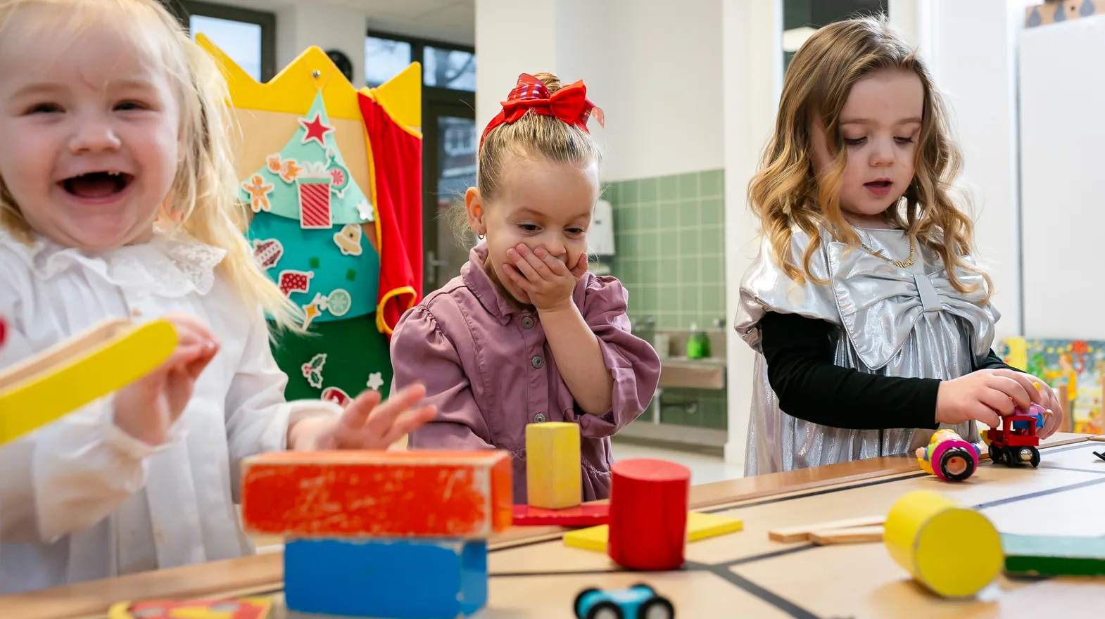 Kinderen van de peutergroep lachen en spelen samen bij kinderopvang Kind&co ludens