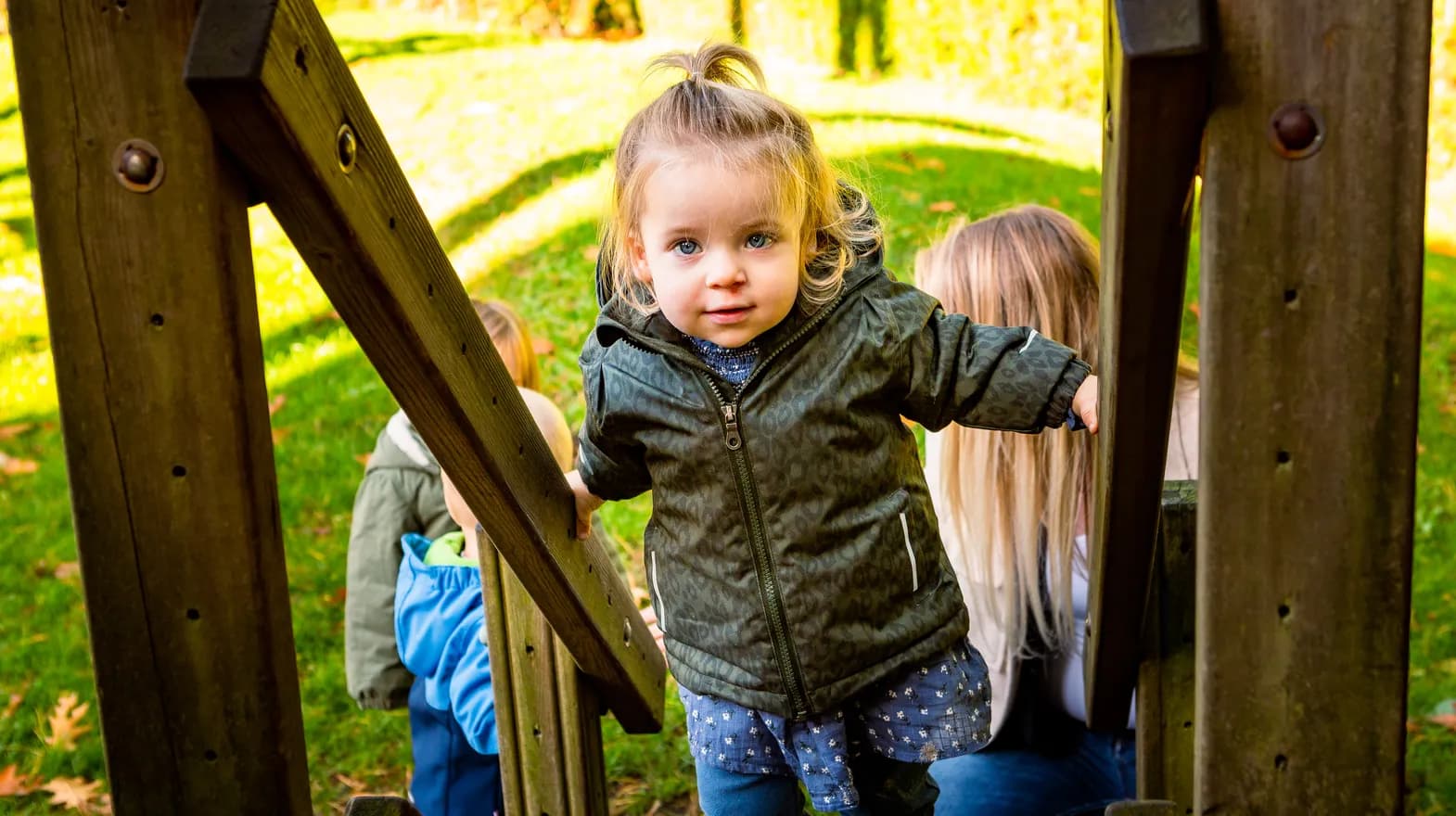 Kind speelt buiten op een speeltoestel bij kinderopvang Kind&co ludens