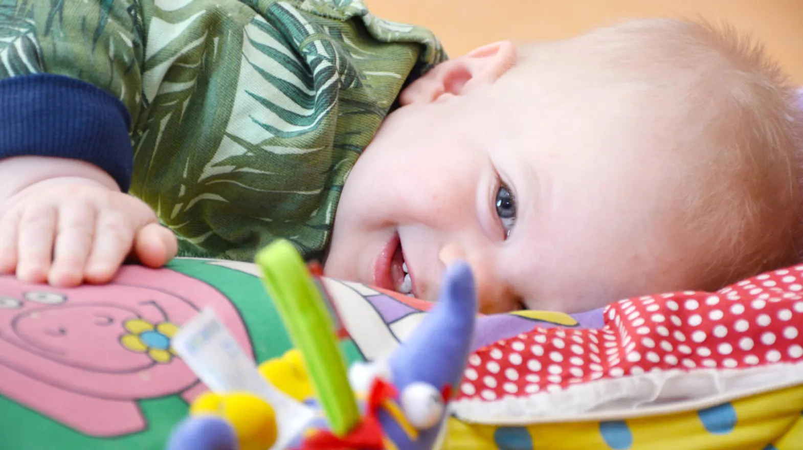 Kind ligt op speelkleed bij Kinderdagverblijf Weesp Speelrijk van kinderopvang Kind&co ludens