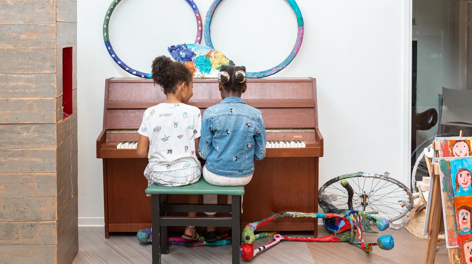 Kinderen spelen samen op de piano bij de BSO van kinderopvang Kind&co ludens