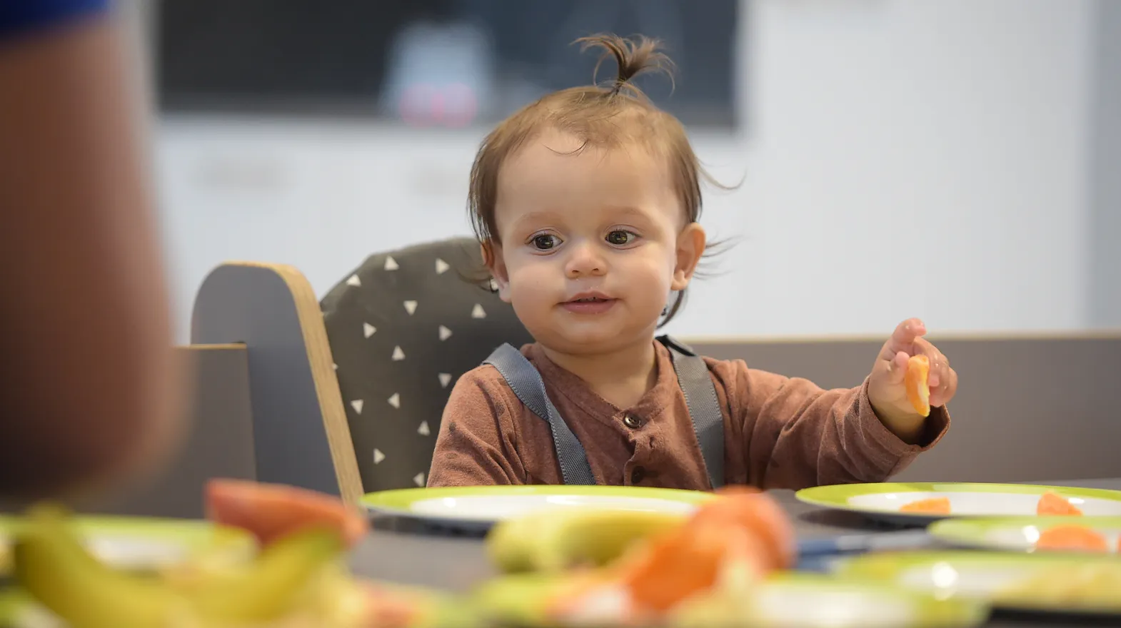 Baby is lekker aan het eten tijdens de lunch bij kinderopvang Kind&co ludens