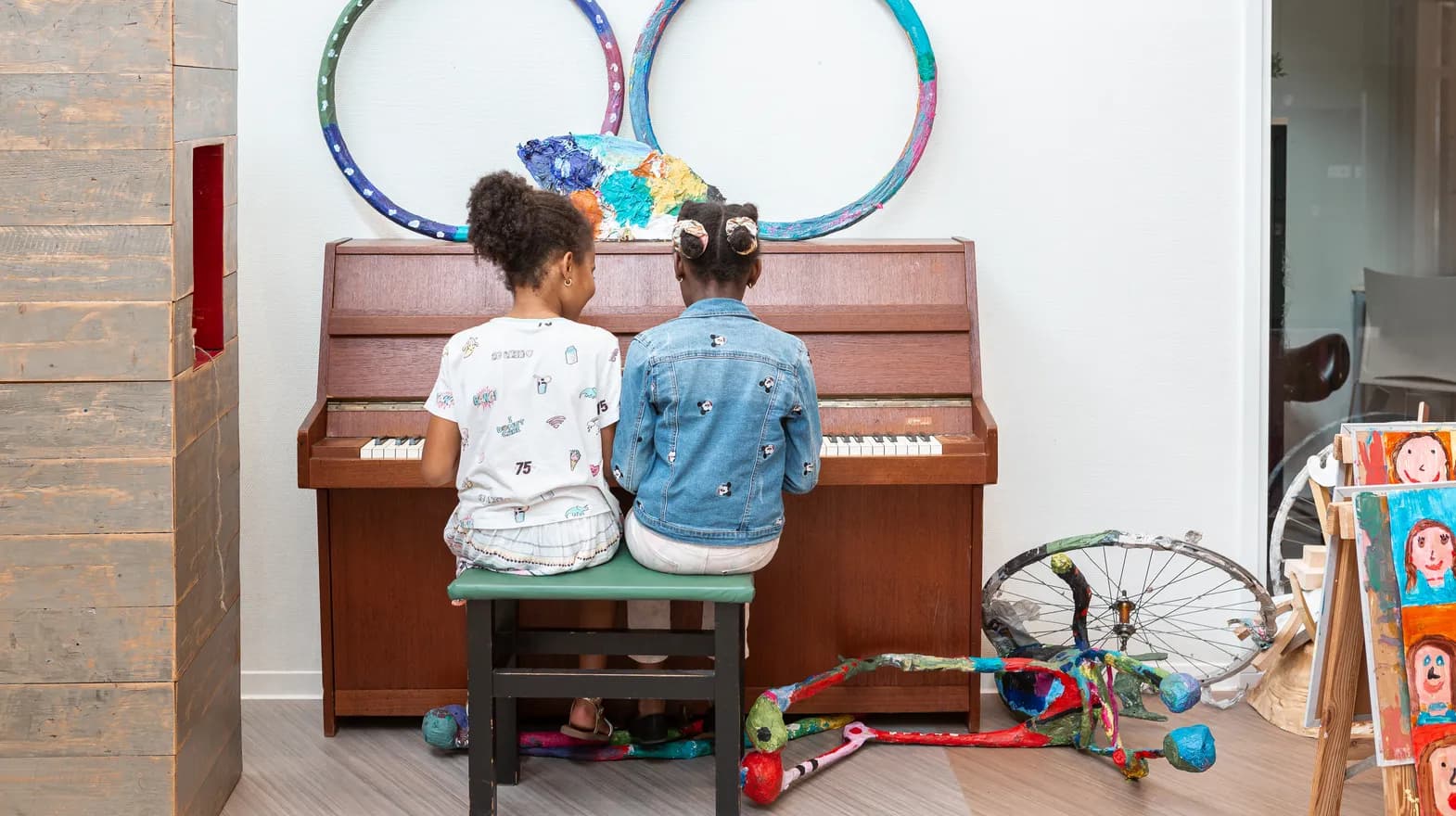 Kinderen spelen samen op de piano bij de BSO van kinderopvang Kind&co ludens