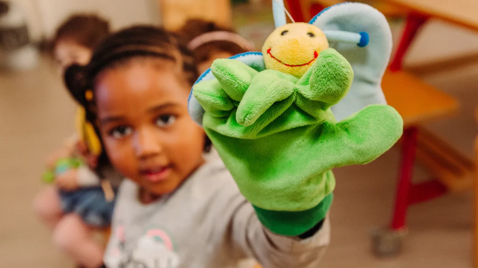 Kind van de peutergroep speelt met handpop bij kinderopvang Kind&co ludens
