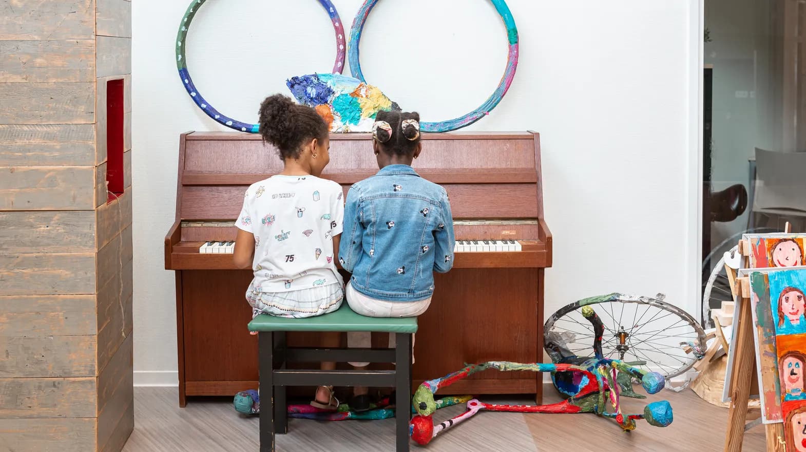 Kinderen spelen samen op de piano bij de BSO van kinderopvang Kind&co ludens