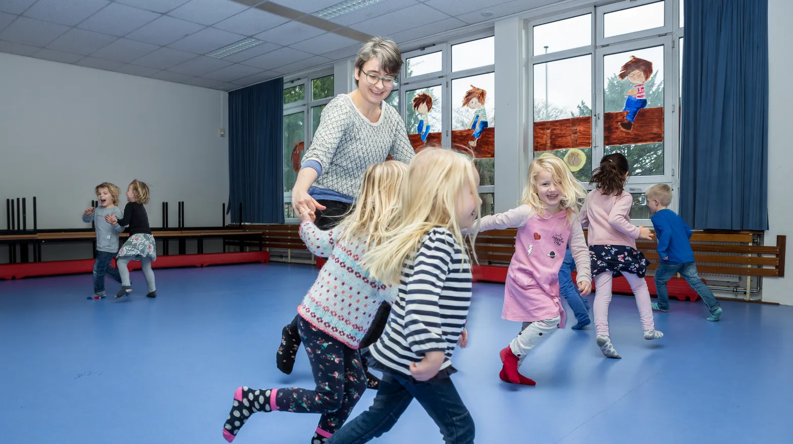 Kinderen van de BSO sporten samen in de gymzaal bij kinderopvang Kind&co ludens