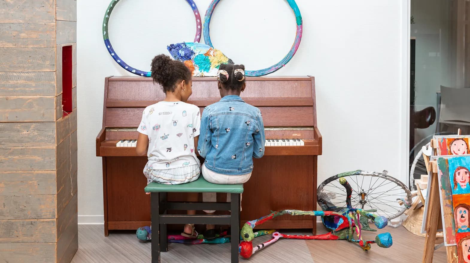 Kinderen spelen samen op de piano bij de BSO van kinderopvang Kind&co ludens