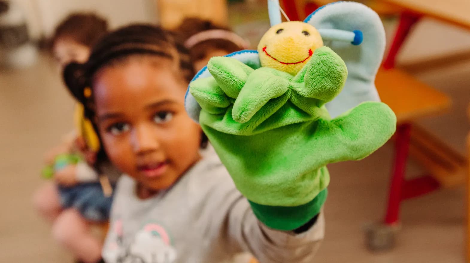 Kind van de peutergroep speelt met handpop bij kinderopvang Kind&co ludens
