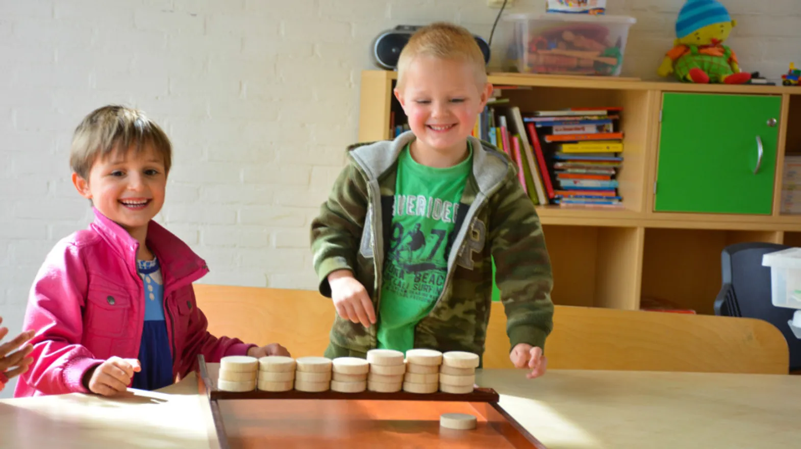 Kinderen sjoelen samen bij buitenschoolse opvang Batau van kinderopvang Kind&co Ludens