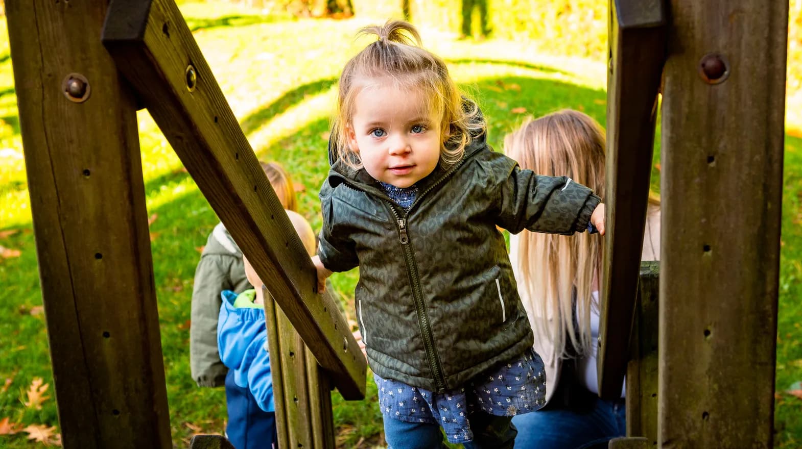 Kind speelt buiten op een speeltoestel bij kinderopvang Kind&co ludens