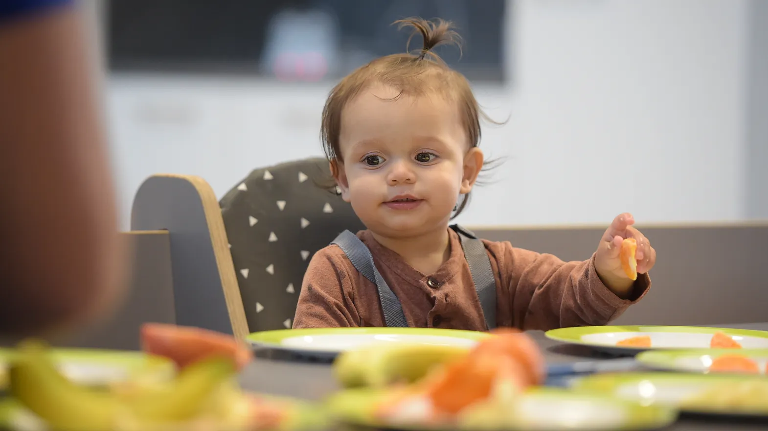 Baby is lekker aan het eten tijdens de lunch bij kinderopvang Kind&co ludens