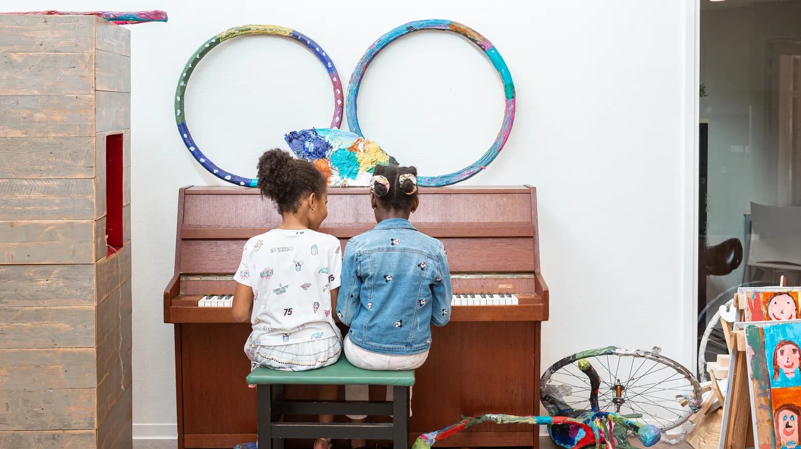 Kinderen spelen samen op de piano bij de BSO van kinderopvang Kind&co ludens