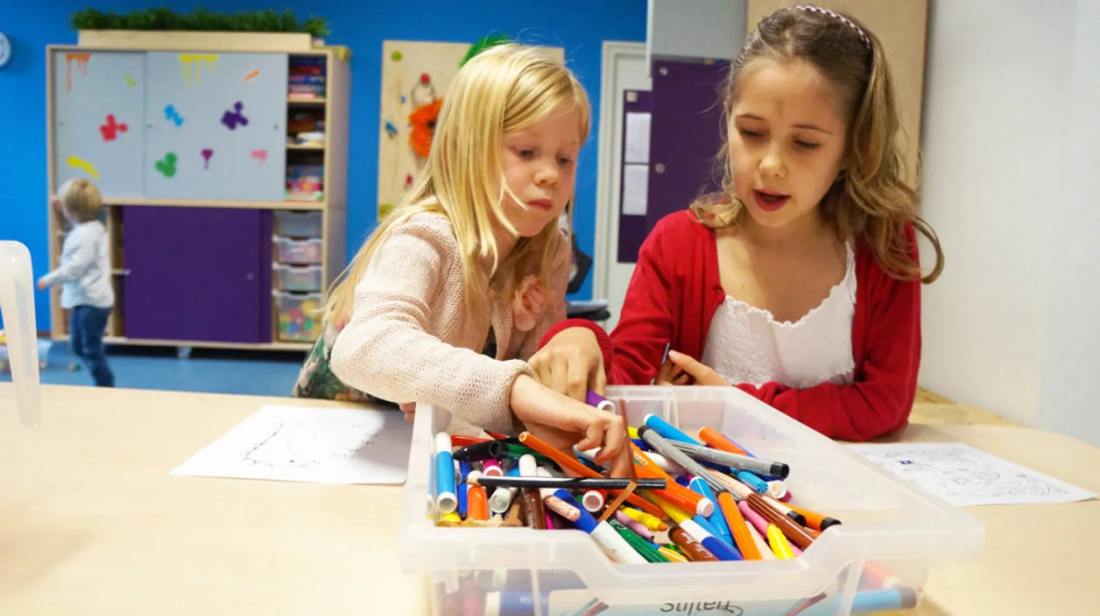Kinderen kleuren een kleurplaat bij buitenschoolse opvang Kameleon, kinderopvang Kind&co Ludens
