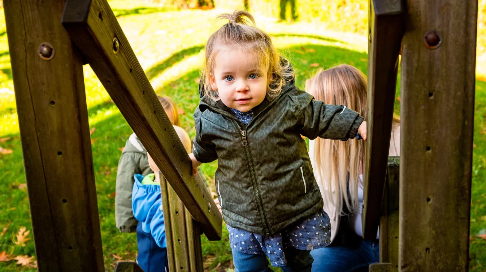 Kind speelt buiten op een speeltoestel bij kinderopvang Kind&co ludens