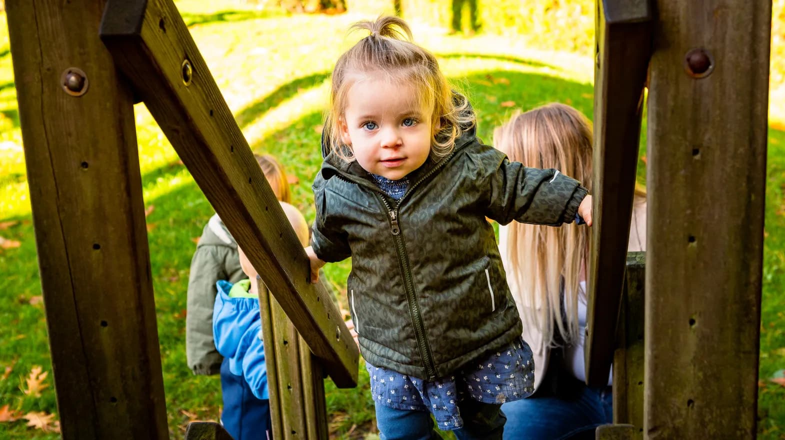 Kind speelt buiten op een speeltoestel bij kinderopvang Kind&co ludens