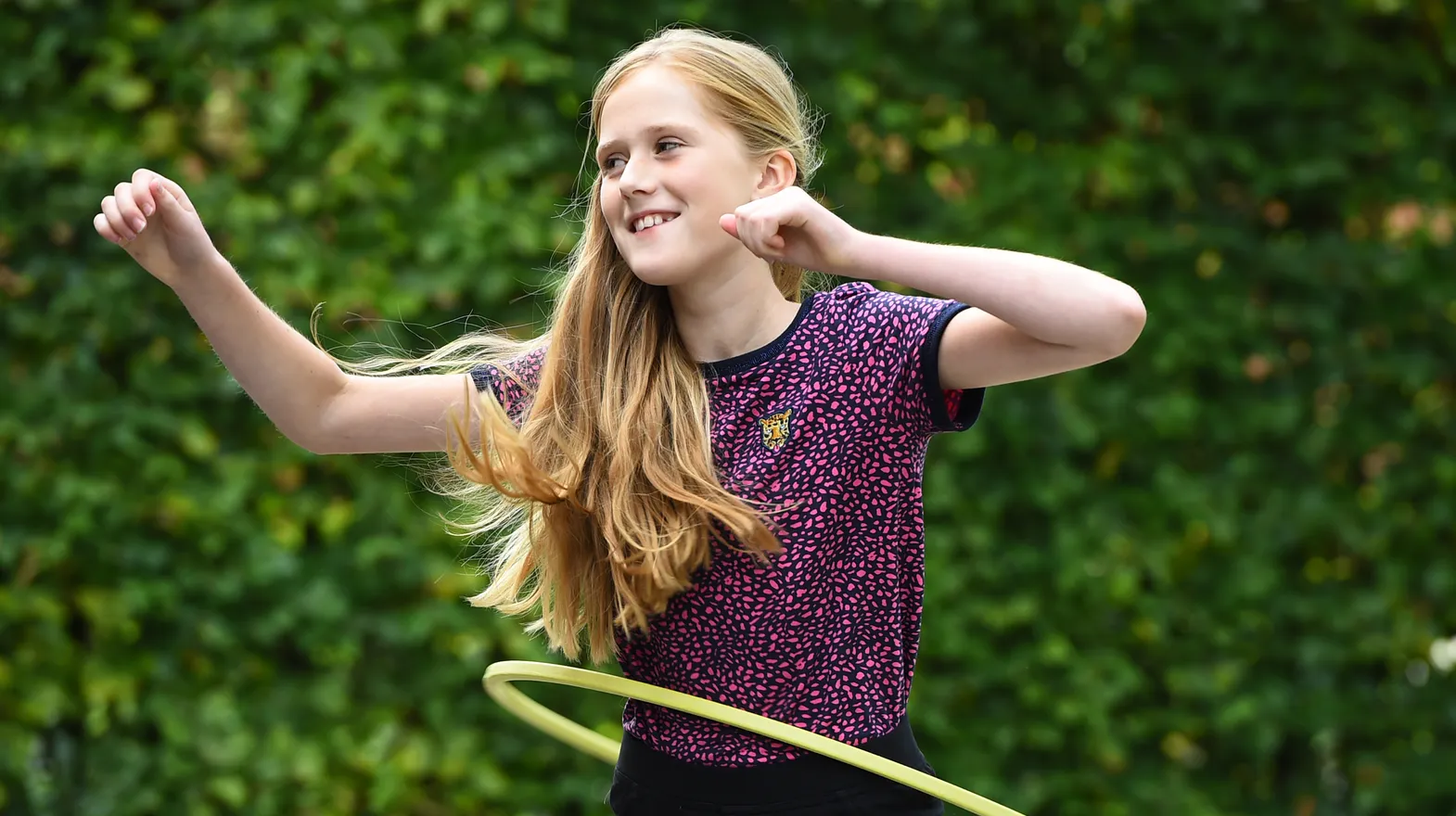 Kind van de BSO hoepelt buiten bij kinderopvang Kind&co ludens