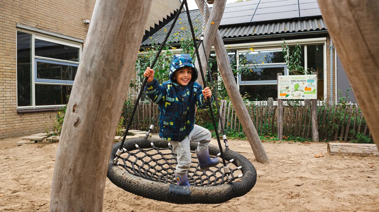 Kind schommelt in tuin van buitenschoolse opvang Ay bij kinderopvang Kind&co ludens