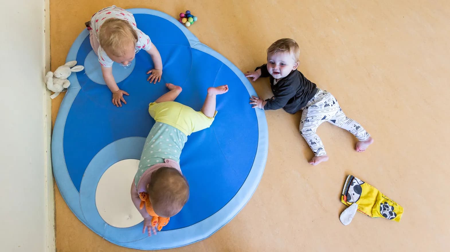 Drie baby's spelen op een speelmat bij kinderdagverblijf Jodokus, kinderopvang Kind&co ludens