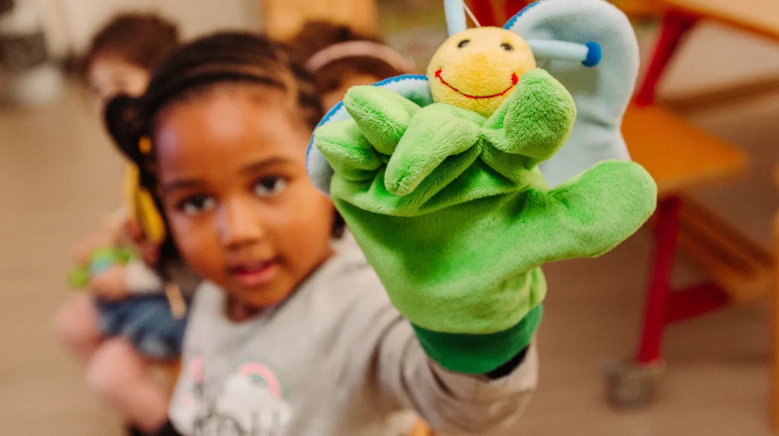 Kind van de peutergroep speelt met handpop bij kinderopvang Kind&co ludens