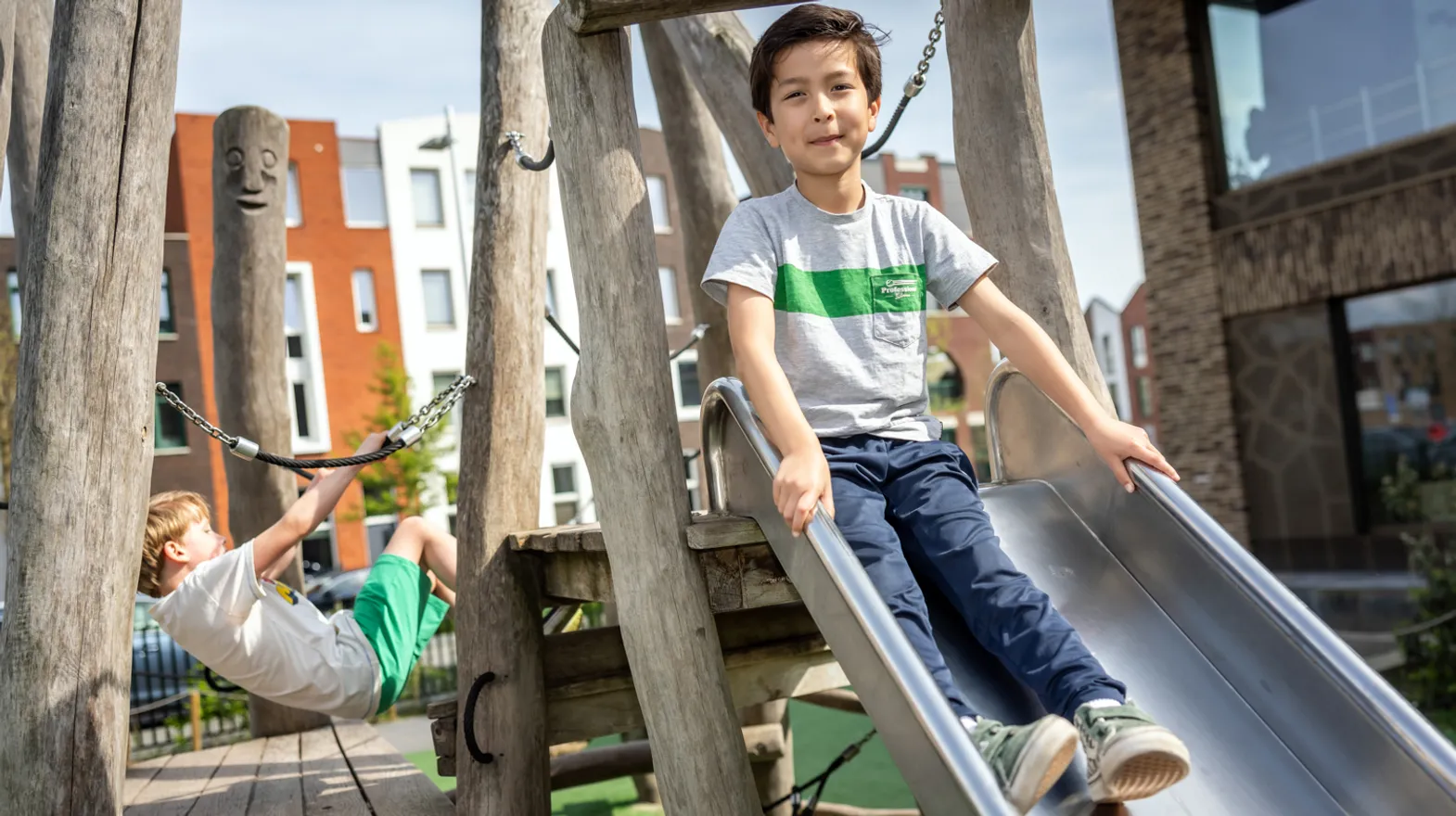 Kinderen spelen buiten met pedagogisch medewerker bij kinderopvang Kind&co ludens