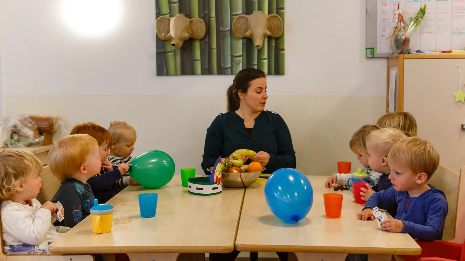Kinderen vieren een feestje aan tafel bij kinderdagverblijf Harlekijn, kinderopvang Kind&co ludens